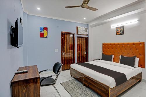 um quarto com uma cama, uma secretária e uma cadeira em Collection O Kanchan Heritage em Gurgaon