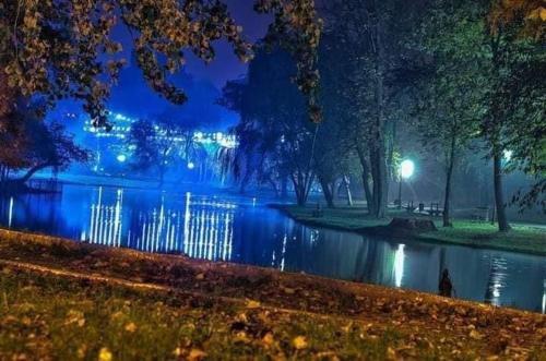 a park at night with a lake and lights at Black&White Studio Ultracentral in Craiova