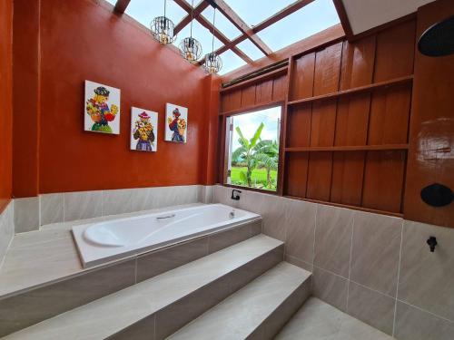 een grote badkamer met een bad en een raam bij Ha Me Garden ฮามีการ์เด้น โฮมสเตย์ฝาง in Fang