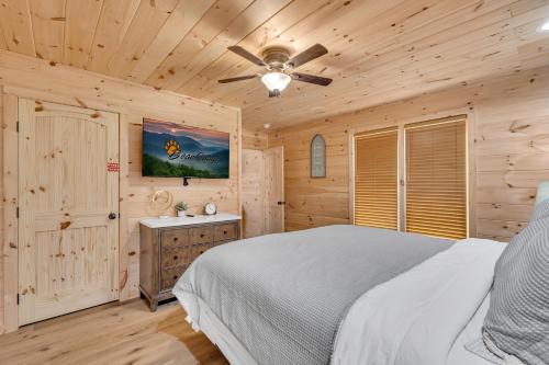 een slaapkamer met een bed en een plafondventilator bij Getaway Cottage - Creek Front, WIFI, Free Attraction Tickets in Cosby