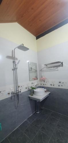 y baño con lavabo y ducha. en Tam's Homestay en Phong Nha