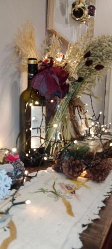 uma mesa com uma garrafa de vinho e um vaso com flores em Tres bel appartement rez de jardin appart de 53m2. em Pfastatt