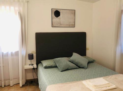 a bed with a black headboard in a bedroom at Dieci7 in Montefiascone