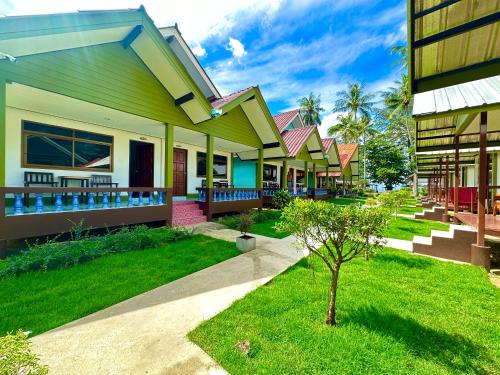 a row of houses with grass and a tree at Lanta L.D. Beach Bungalow in Ko Lanta