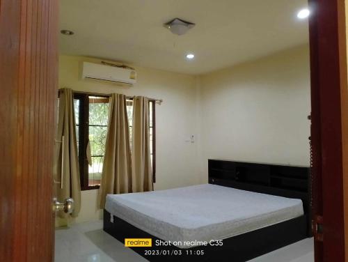 a bedroom with a bed and a window at 2 one bedroom houses 400 meters from the deach in Amphoe Koksamui