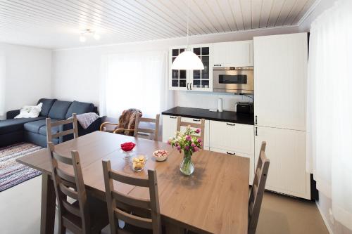 a kitchen and dining room with a table with flowers on it at Tervalepikon Torpat in Sysmä