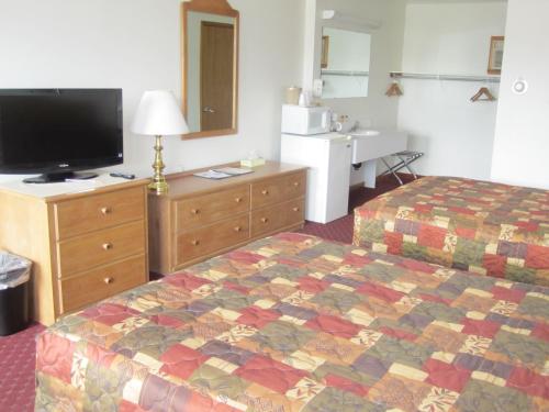 a hotel room with a bed and a television at Bishops Country Inn Motel in Jackman