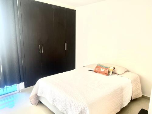 a bedroom with a bed with a black cabinet at Habitación confortable in Valledupar