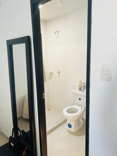 ein Bad mit einem WC und einem Spiegel in der Unterkunft Habitación confortable in Valledupar