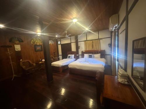 a bedroom with two beds in a room at KhounPhet GuusetHous Luangprabang in Luang Prabang