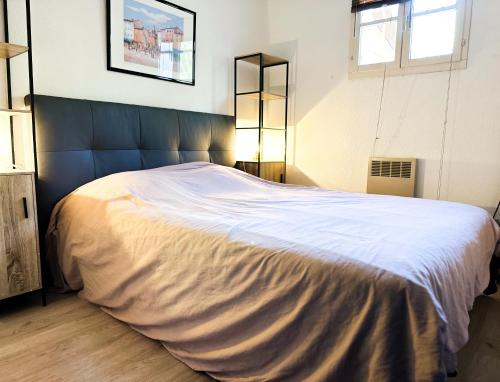 - une chambre avec un grand lit blanc et une tête de lit bleue dans l'établissement Appartement Port Grimaud 2/4 pers avec grande terrasse, à Grimaud