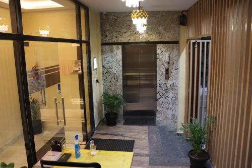 un couloir dans un bâtiment avec une table et quelques plantes dans l'établissement Otel Feel Comfort, à Bangalore