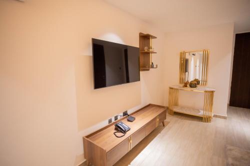 a living room with a tv on the wall at Veronique Heights in Kumasi