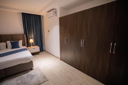 a hotel room with a bed and wooden cabinets at Veronique Heights in Kumasi