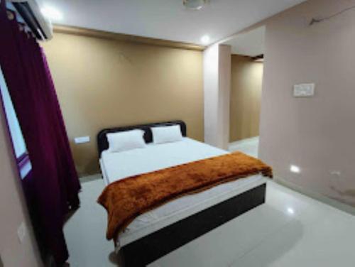1 dormitorio con 1 cama con manta marrón en Hotel Kanha Shyam Madhubani en Madhubani