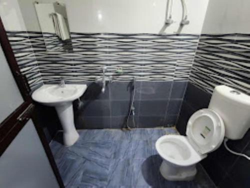 a bathroom with a toilet and a sink at Hotel Kanha Shyam Madhubani in Madhubani