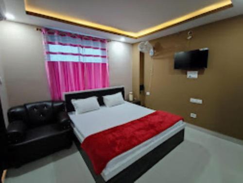 1 dormitorio con cama, sofá y TV en Hotel Kanha Shyam Madhubani en Madhubani
