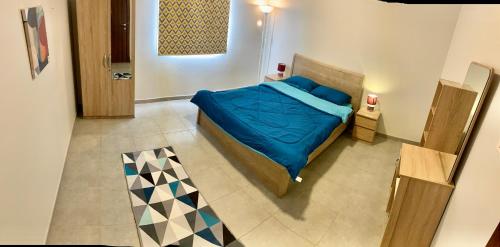 阿卜杜勒国王经济城KAEC Garden View - مدينة الملك عبدالله الاقتصادية的一间卧室配有一张带蓝色棉被的床