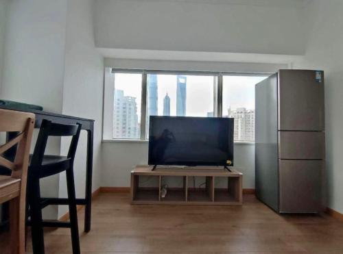 a living room with a tv and a table with a tvictericterictericter at iNestin Shanghai Apt Lujiazui in Shanghai