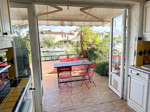 Il dispose d'une terrasse avec une table et des chaises. dans l'établissement Appartement Port Grimaud 2/4 pers avec grande terrasse, à Grimaud