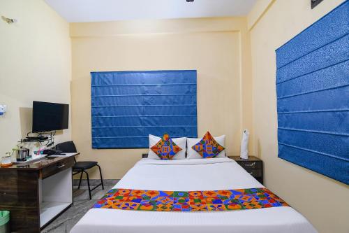 Dormitorio con cama, escritorio y TV en FabHotel Sapphire Comfort, en Calcuta