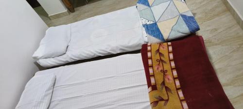 a bed with white sheets and ties on it at Raagabynature home stay in Gendehalli