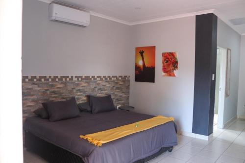 a bedroom with a bed with a yellow blanket on it at Big D Accommodation & guesthouse in Northam