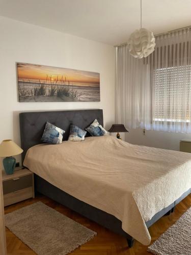 a bedroom with a large bed with blue pillows at Villa Feodora in Biograd na Moru