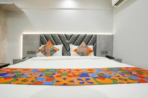 1 dormitorio con 1 cama grande y colcha colorida en FabHotel Aahan en Navi Mumbai