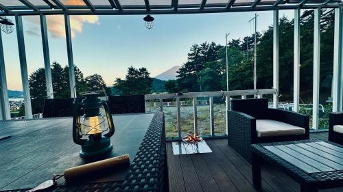 a balcony with a table and a lamp and a chair at glampark S.O.P Fuji Kawaguchi Lake in Fujikawaguchiko
