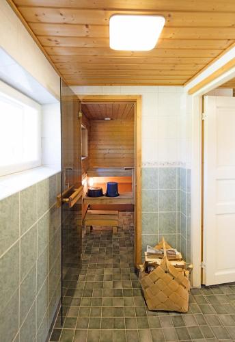 a bathroom with a sauna with a wooden ceiling at Tervalepikon Torpat in Sysmä