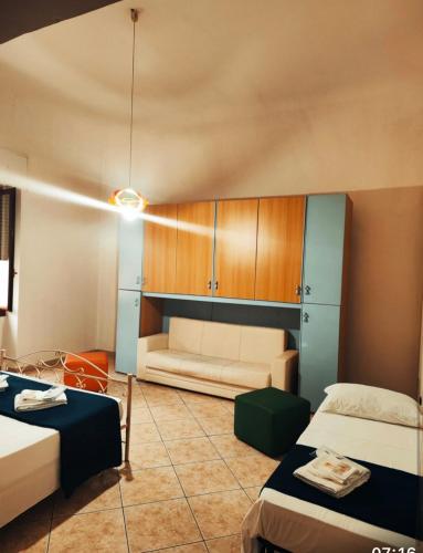 een woonkamer met 2 bedden en een bank bij Casa roberta 2 in Taranto