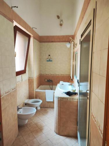 een badkamer met een toilet, een wastafel en een bad bij Casa roberta 2 in Taranto
