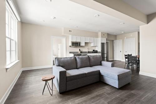 a living room with a couch and a kitchen at Holy Angels Bywater Hotel and Residences in New Orleans