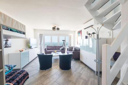 a living room with a couch and a table at Prachtig zeezicht tot 6 personen met garage in Middelkerke
