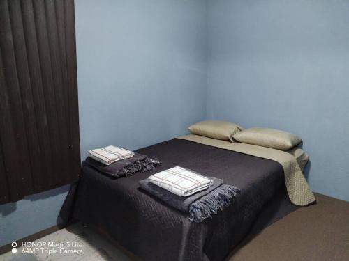 a bed with two pillows on it in a room at Casa Hortensia in La Cañada