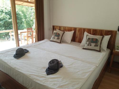 Un dormitorio con una cama con sombreros. en Meexok river view, en Nongkhiaw