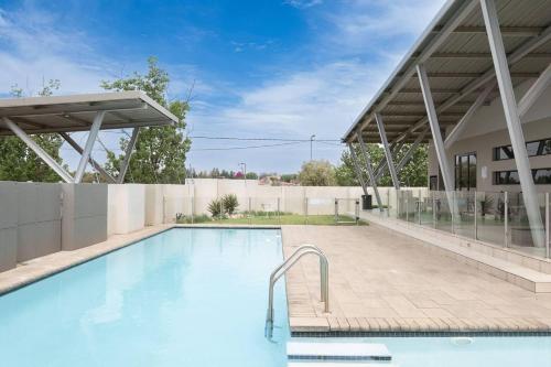 a swimming pool in front of a building at Explore this stylish and classy apartment in Sandton