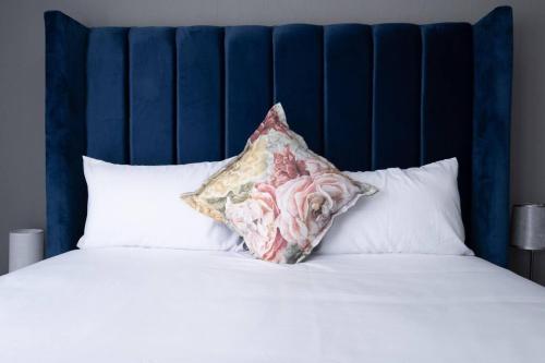 a pillow sitting on top of a bed with white pillows at Explore this stylish and classy apartment in Sandton