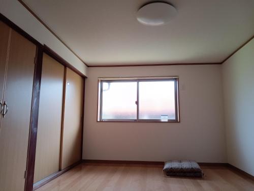 an empty room with a window and a door at ゲストハウス ふしの庵 in Ogori