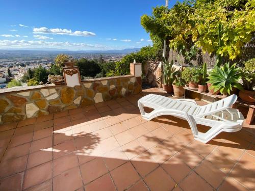 una panchina bianca seduta in cima a un patio di VillaSanMiguelAlto a Granada