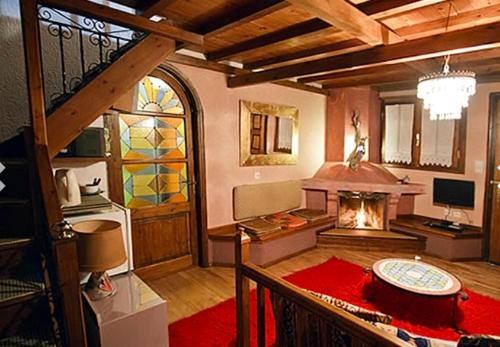 a living room with a fireplace and a staircase at Guesthouse Mylona in Arachova