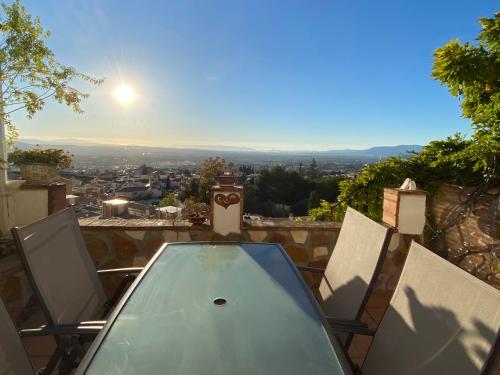 un tavolo in vetro e sedie su un balcone con vista di VillaSanMiguelAlto a Granada