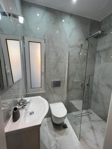a bathroom with a toilet and a sink and a shower at Selenity studio(close to two metro stations) in Piraeus