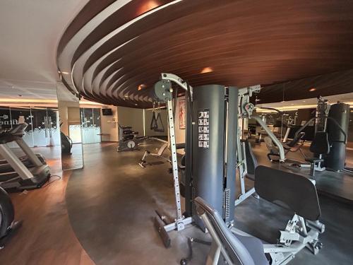 a gym with treadmills and machines in a room at Five Leo’s villa in Gadok 1