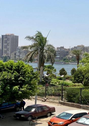 Riverfront Apartment 1 في القاهرة: سيارتين متوقفتين في موقف للسيارات بجانب تجمع المياه