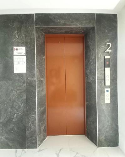 an elevator in a building with a brown door at The 9 Residence Hotel in Bangkok