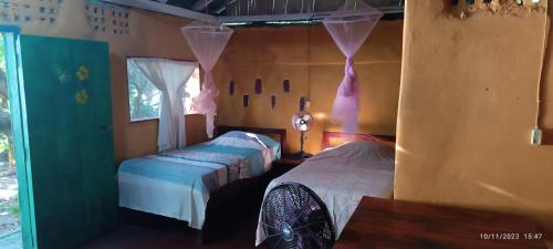1 dormitorio con 2 camas y ventana en Hostel La Gloria en Ometepe