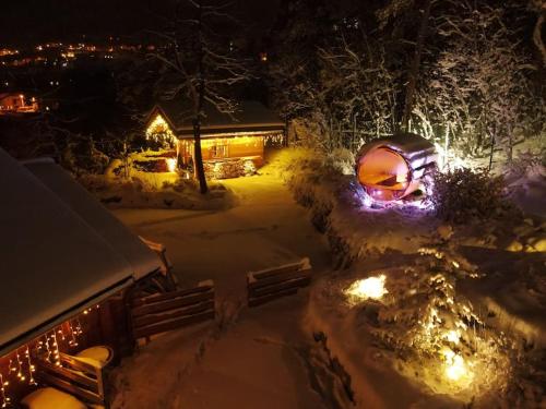 a house covered in snow at night with lights at CHALET LUXE DE LA CROIX DU FRENE in Briançon