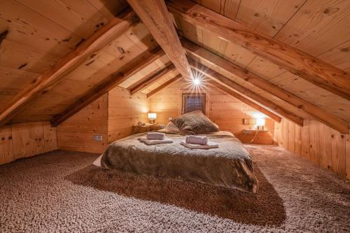 a bedroom in a log cabin with a large bed at CHALET LUXE DE LA CROIX DU FRENE in Briançon